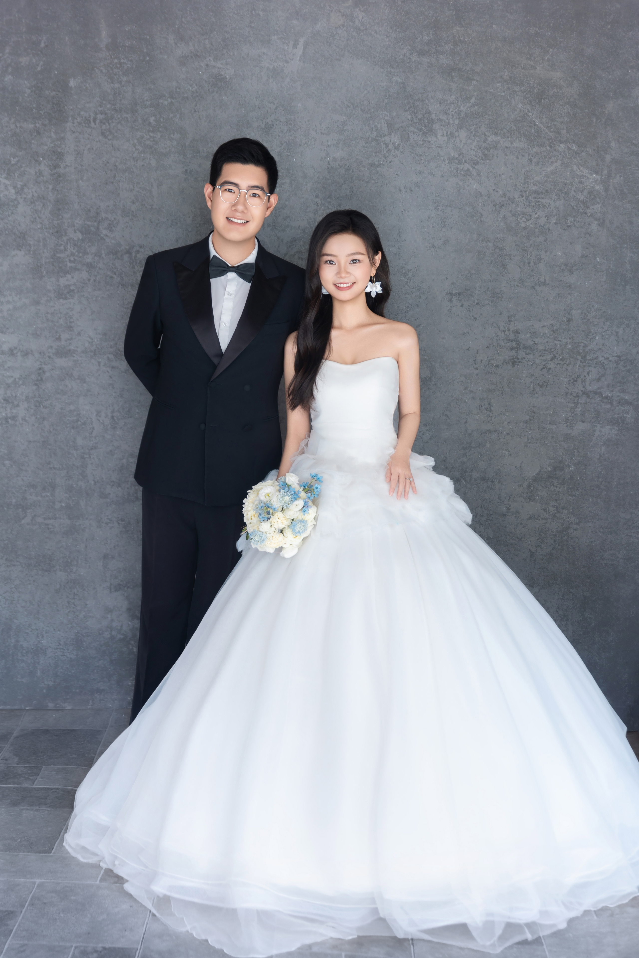 灰墙前的新人与婚纱全身合影